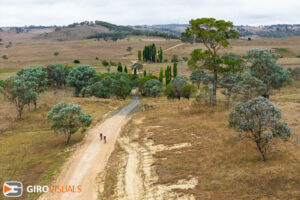 These riders are at the crest of a hill. From above I can see what down below and beyond.